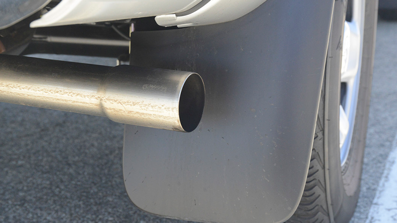 A metal tailpipe on the back of a car.