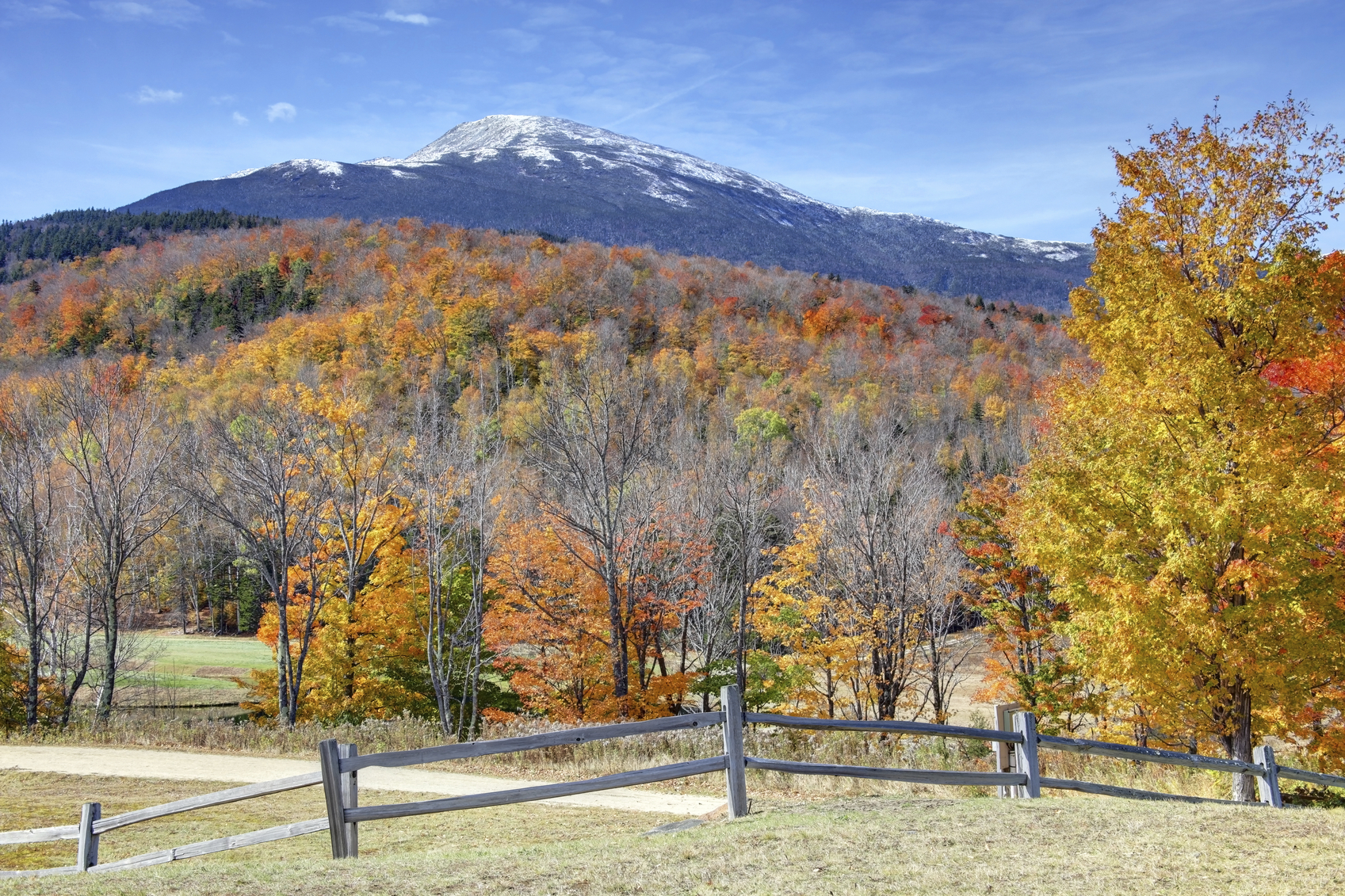 Snowcapped mountains in the White Mountains National Forest in New Hampshire during the autumn foliage season. Photo taken during the peak fall foliage season. New Hampshire is one of New England's most popular fall foliage destinations bringing out some of the best foliage in the United States