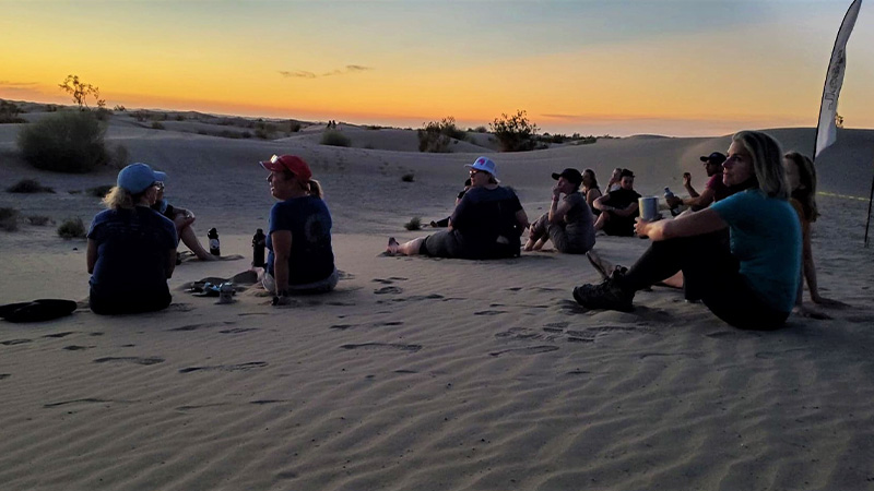 rally participants on the sand at sunset