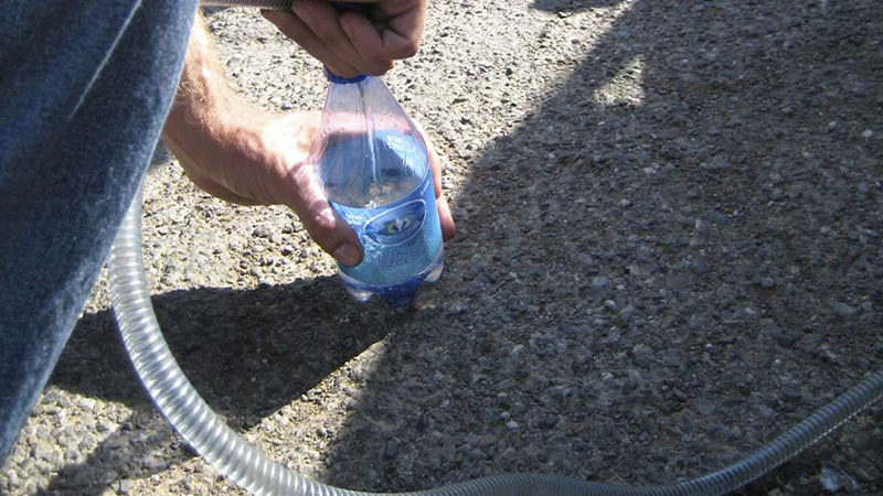 siphoning fuel into a bottle