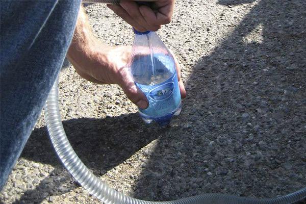 siphoning fuel into a bottle