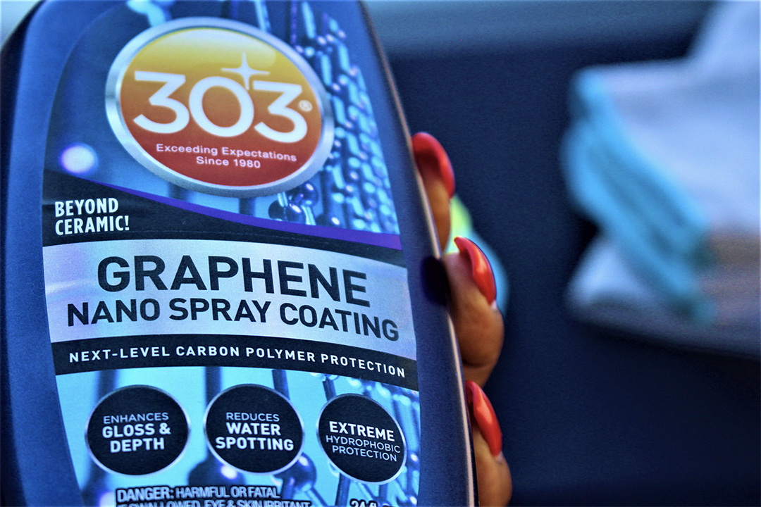 closeup of a bottle of 303 Graphene Nano Spray held by a woman's hand with bright red nails