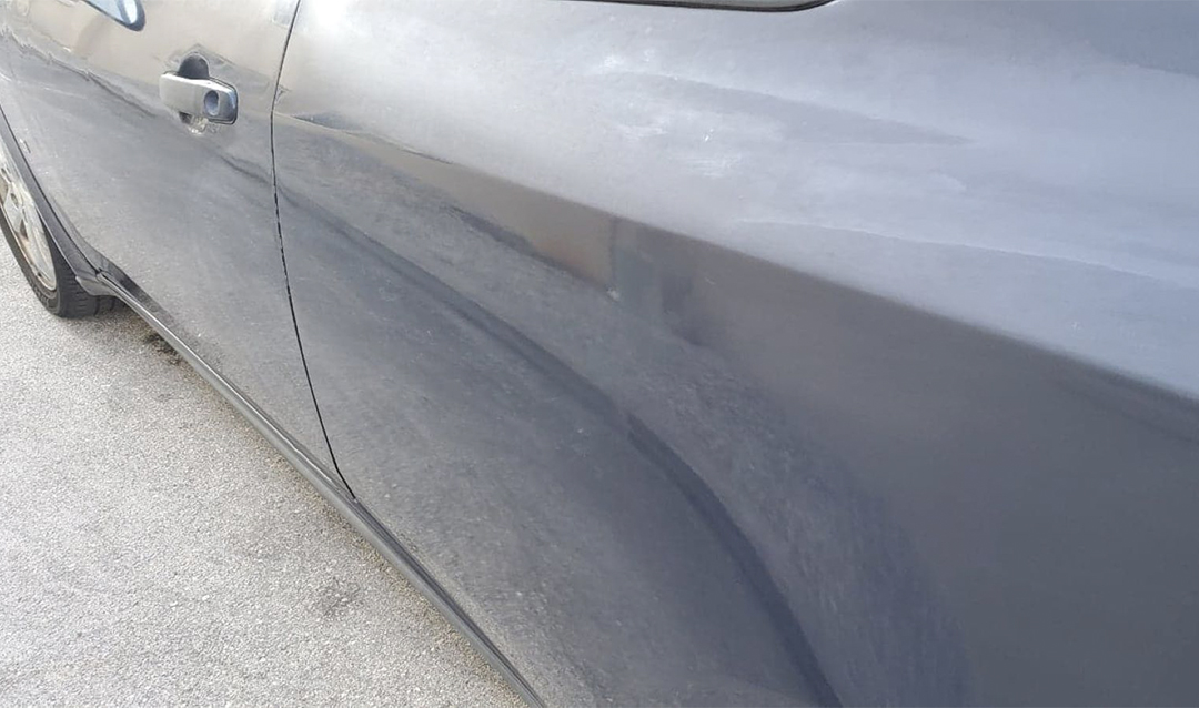 side view of a black vehicle sprayed with 303 Graphene Nano Spray shows a white haze after drying