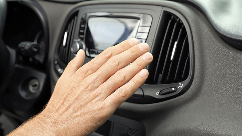 a man's hand in front of an A/C vent
