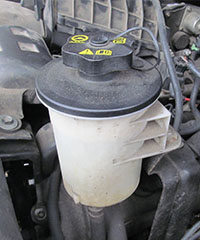 a power steering fluid reservoir under the hood