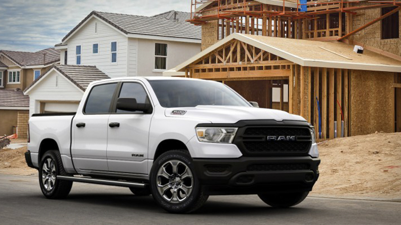 a white Dodge Ram parked outside of a residential construction site