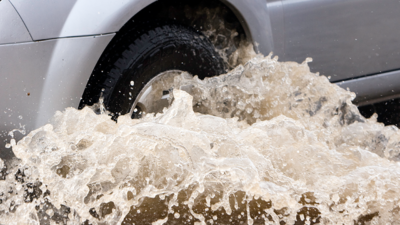 Flood waters splash against tires