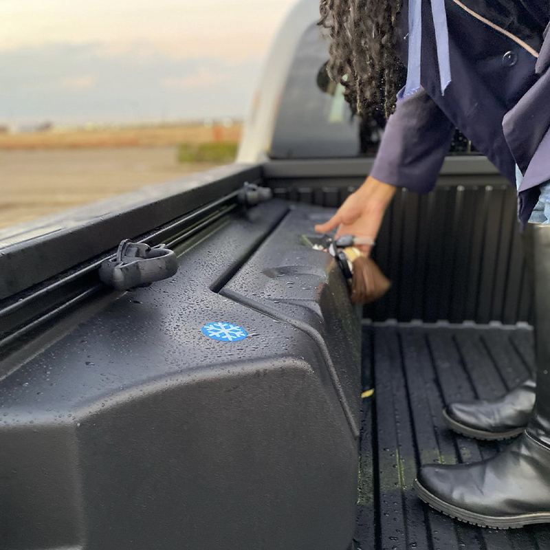 Woman accessing a storage compartment in a truck bed
