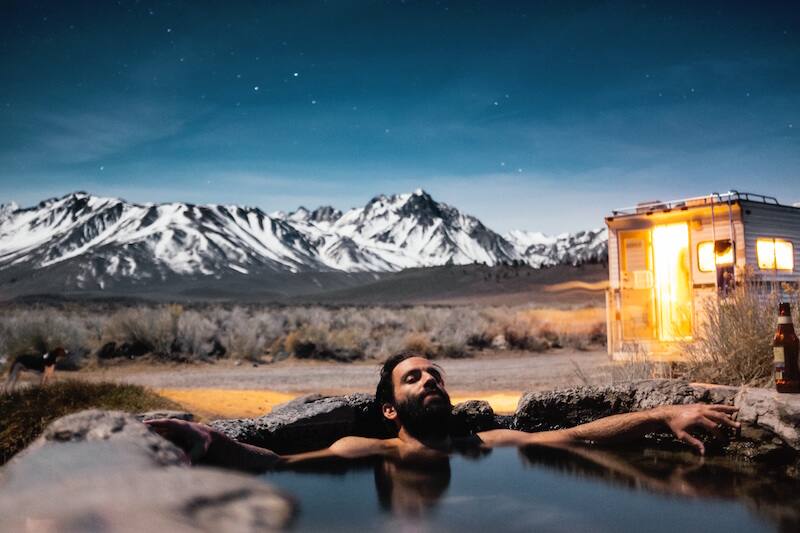 man relaxes in hot springs