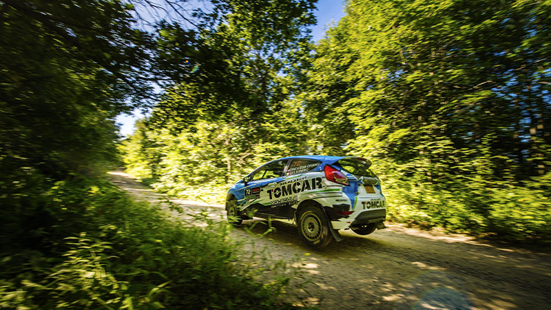 Keanna Erickson-Chang in a rally car on a wooded trail