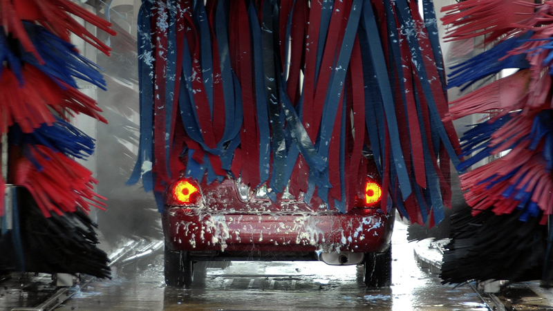 rear view of a red car going through a car wash