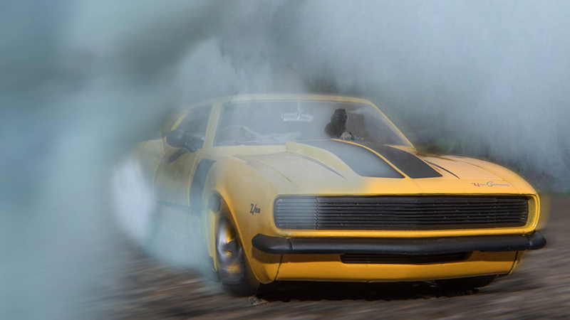 A yellow camaro with black stripes is drifting.